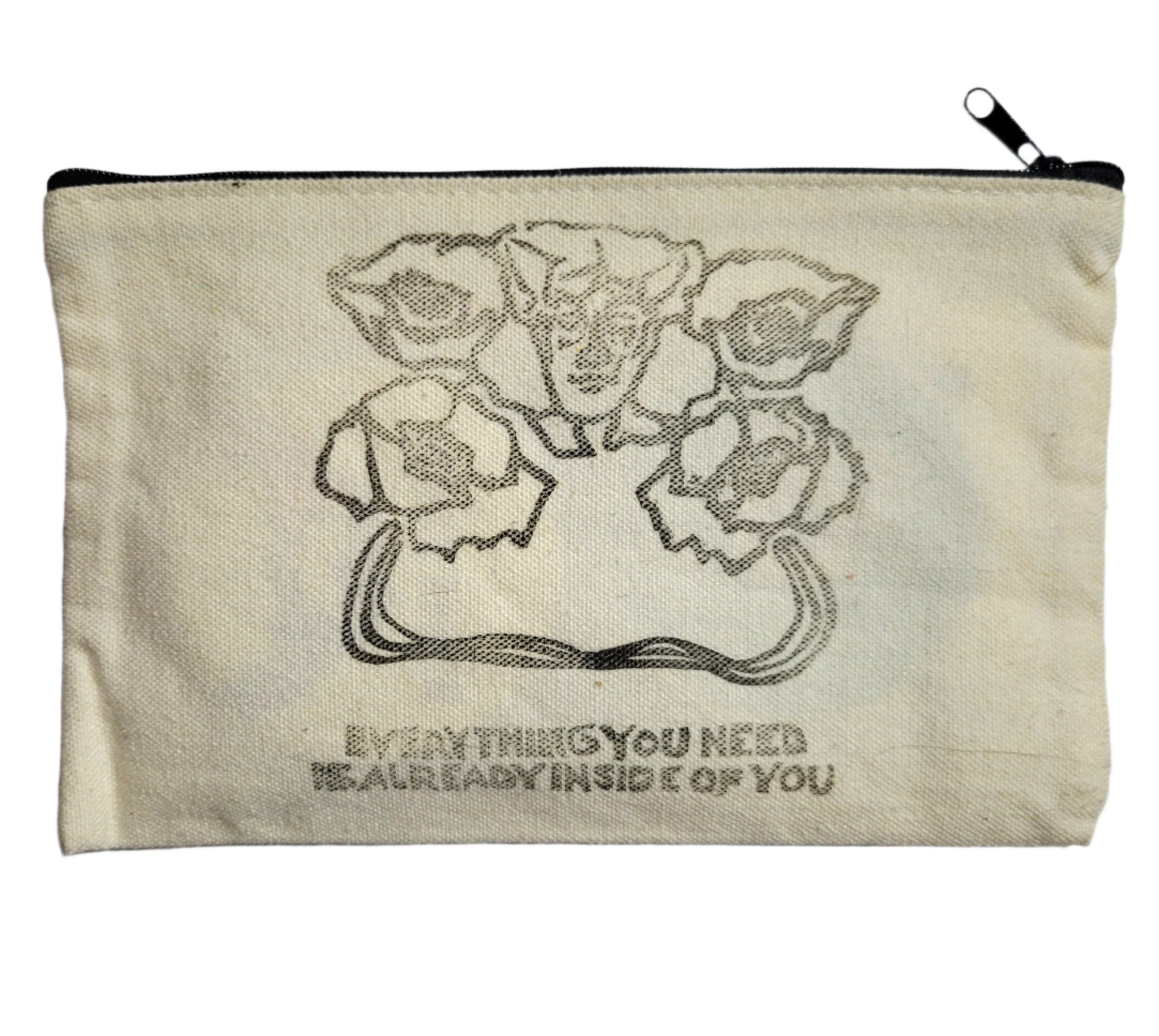 A large canvas coin pouch with the words "everything you need is already inside of you" printed inside along with flowers resembling a woman.